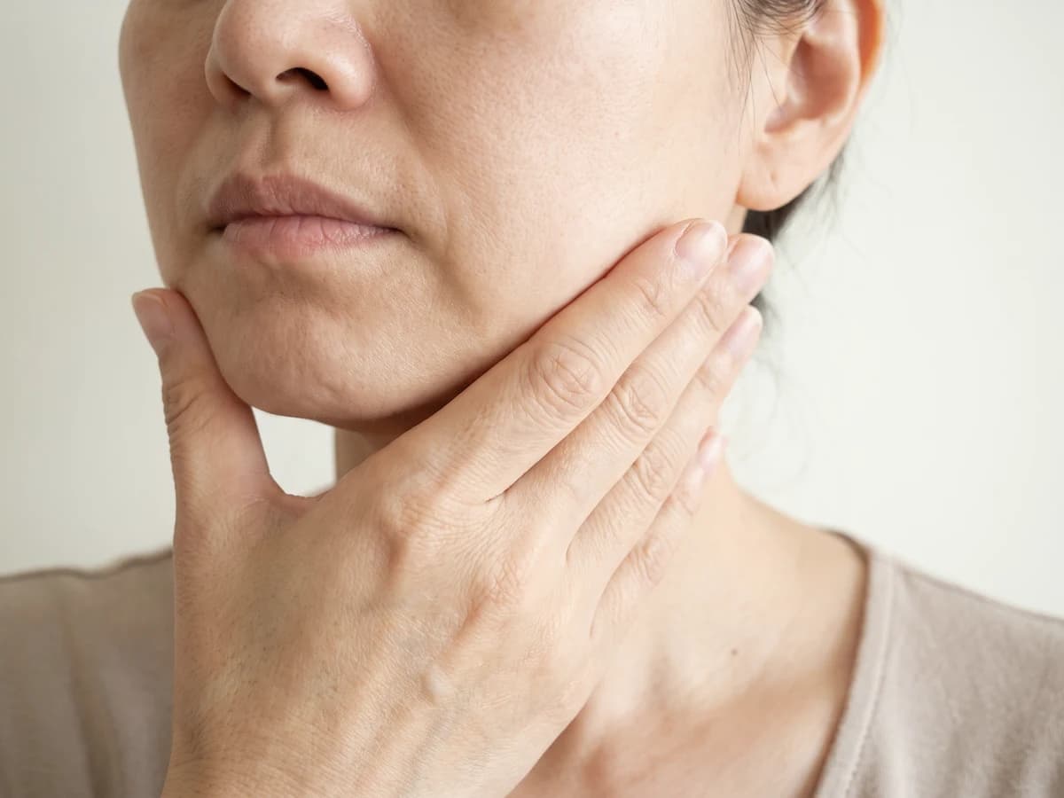 한 손바닥으로 처진 볼과 턱선을 받쳐 보는 얼굴 아래쪽 사진